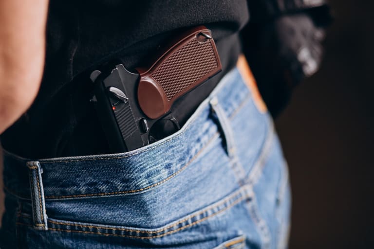 Edital do concurso Polícia Civil SC com divulgação próxima Arma de fogo em coldre policial na cintura representando equipamento da Polícia Civil