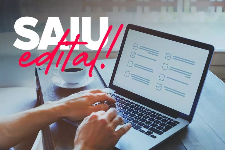 Mãos digitando em notebook com formulário de checklist na tela e xícara de café ao lado representando inscrição em concurso público
