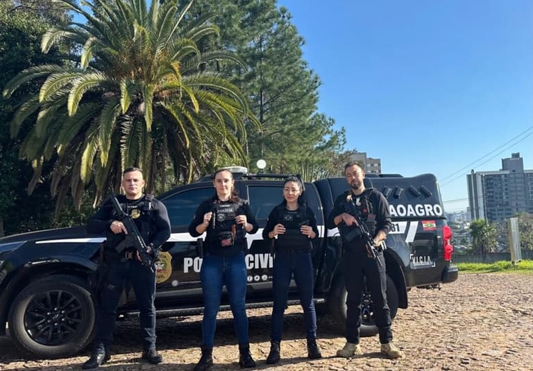 Quatro policiais civis fardados posando em frente a viaturas da Polícia Civil de Santa Catarina representando o concurso da PC SC 2026 com gabaritos e nota mínima para aprovação