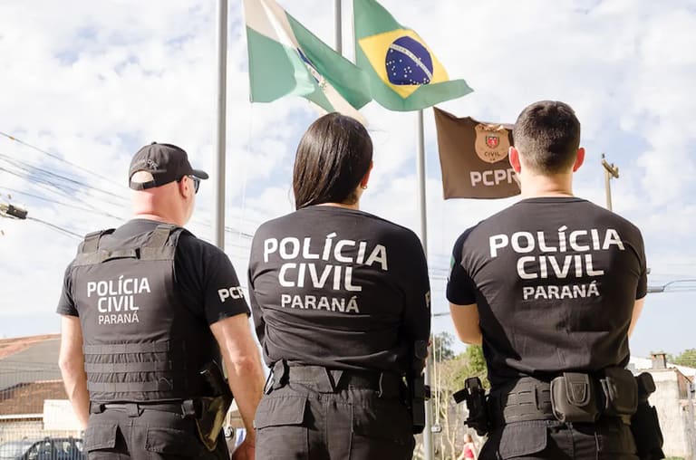 Policiais da Polícia Civil do Paraná posando em frente às bandeiras, representando atualizações sobre o concurso com três bancas na disputa.