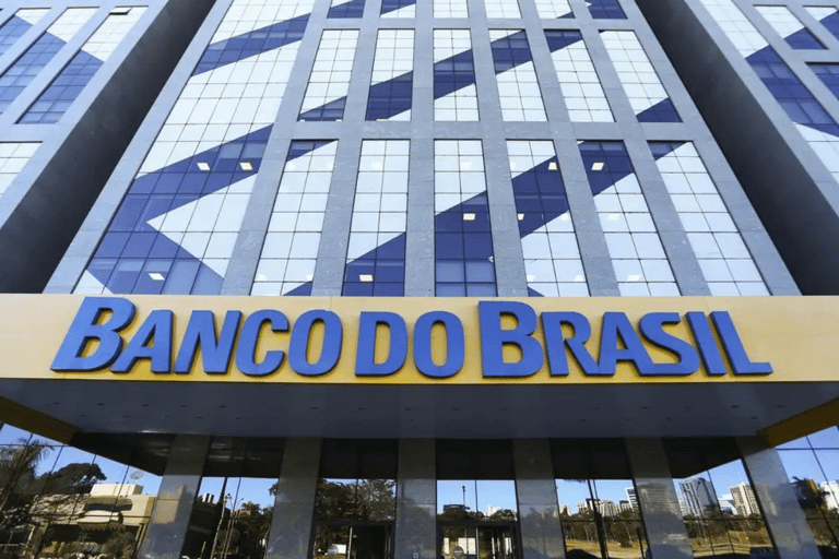 Edifício corporativo com fachada de vidro azul e amarelo com letreiro Banco do Brasil na entrada