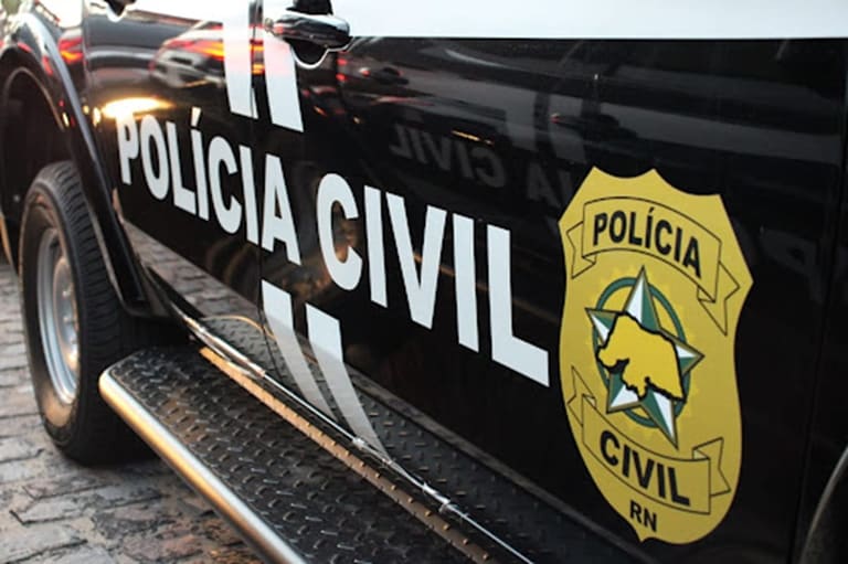 Viatura preta da Polícia Civil com brasão dourado sobre anúncio do concurso da PC do Acre com 139 vagas