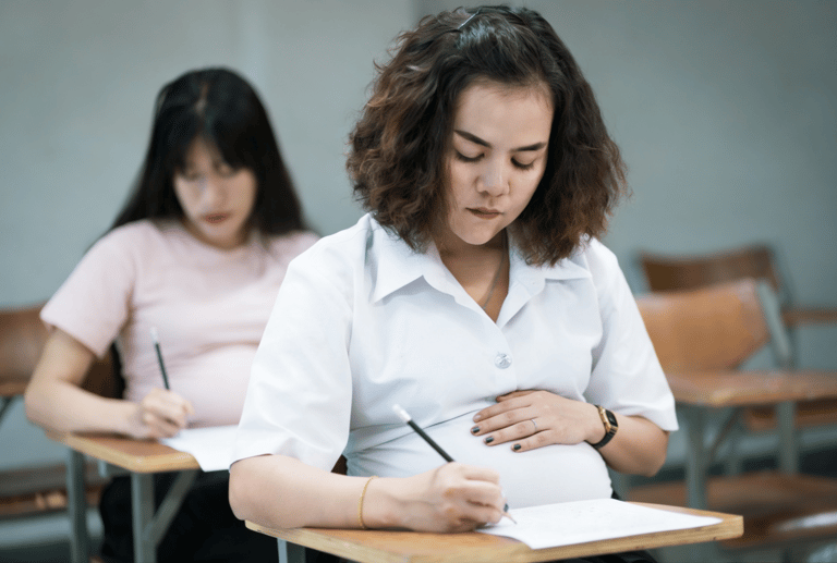 Segunda chamada para grávidas e puérperas. Mulheres grávidas realizando prova em sala de aula escolar.