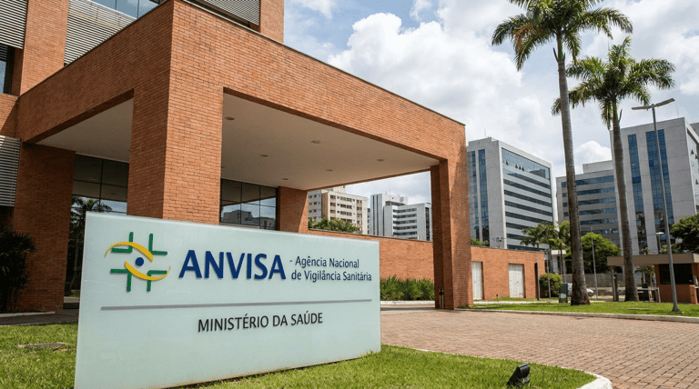 Fachada do edifício sede da Agência Nacional de Vigilância Sanitária (Anvisa) com placa institucional verde e branca.