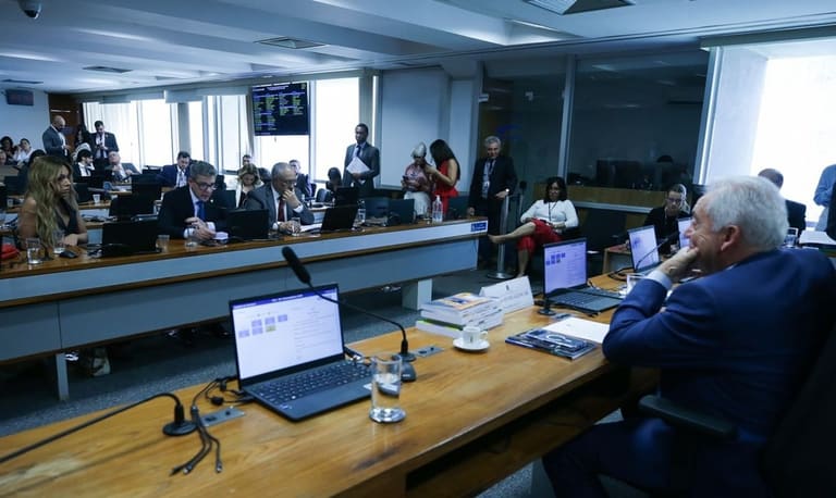 Senadores reunidos em bancada durante sessão de comissão no Senado Federal