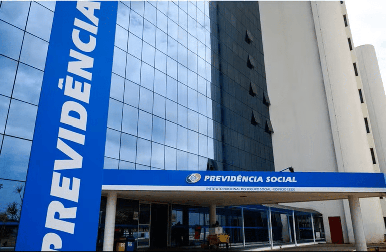 Fachada do prédio do INSS com letreiro azul "Previdência Social" e vidros espelhados em Brasília