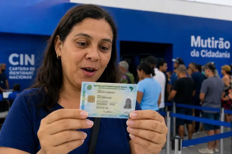 Mulher observando a nova Carteira de Identidade Nacional, representando o mutirão para emissão do documento a partir desta segunda-feira (1º).
