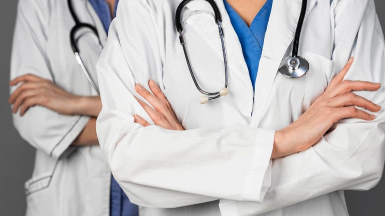 Médicos de jaleco com estetoscópio, representando novo piso salarial para médicos e dentistas aprovado em comissão do Senado.