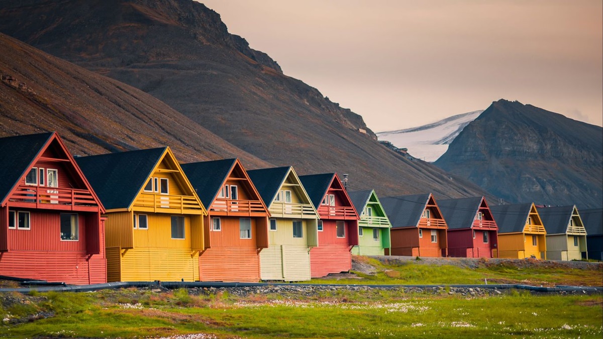 A cidade onde é proibido morrer: Conheça o lugar mais bizarro do mundo onde as leis desafiam a lógica 2 Linha de casas coloridas em Longyearbyen, Noruega, ao lado de montanhas e neve
