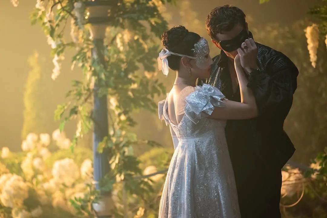 'Bridgerton': 1ª parte da 4ª temporada já está disponível 2 Casal de máscaras da da serie Bridgerton com roupas elegantes se aproximando em jardim iluminado