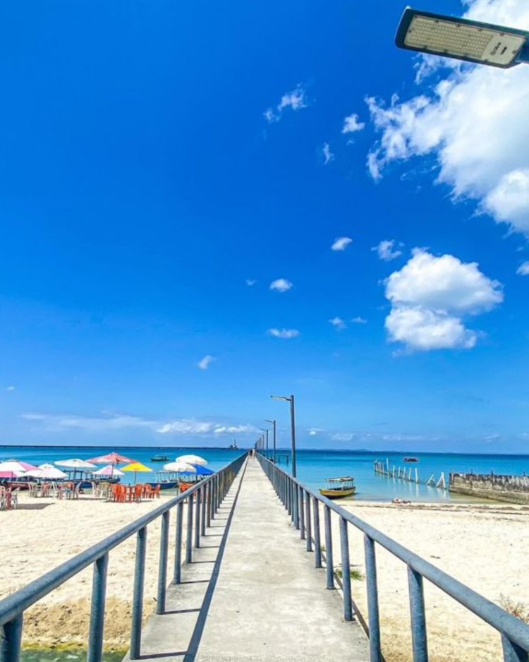 Caribe baiano: essa praia deslumbrante é pouco conhecida pelos turistas 2 Passarela à beira-mar, céu azul, cadeiras e guarda-sóis coloridos na praia nordestina