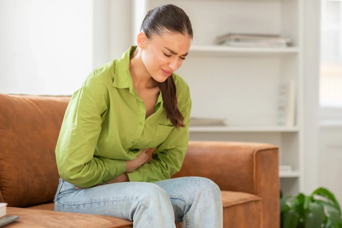 O que acontece com o seu corpo se você beber café de estômago vazio todos os dias? 2 Pessoa com dor abdominal, expressando desconforto após tomar café em jejum.