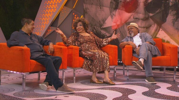 Fãs ganham nova chance: Alcione, Jorge Aragão e Zeca Pagodinho anunciam data extra 2 Três artistas sentados em poltronas laranja conversam animados em cenário descontraído