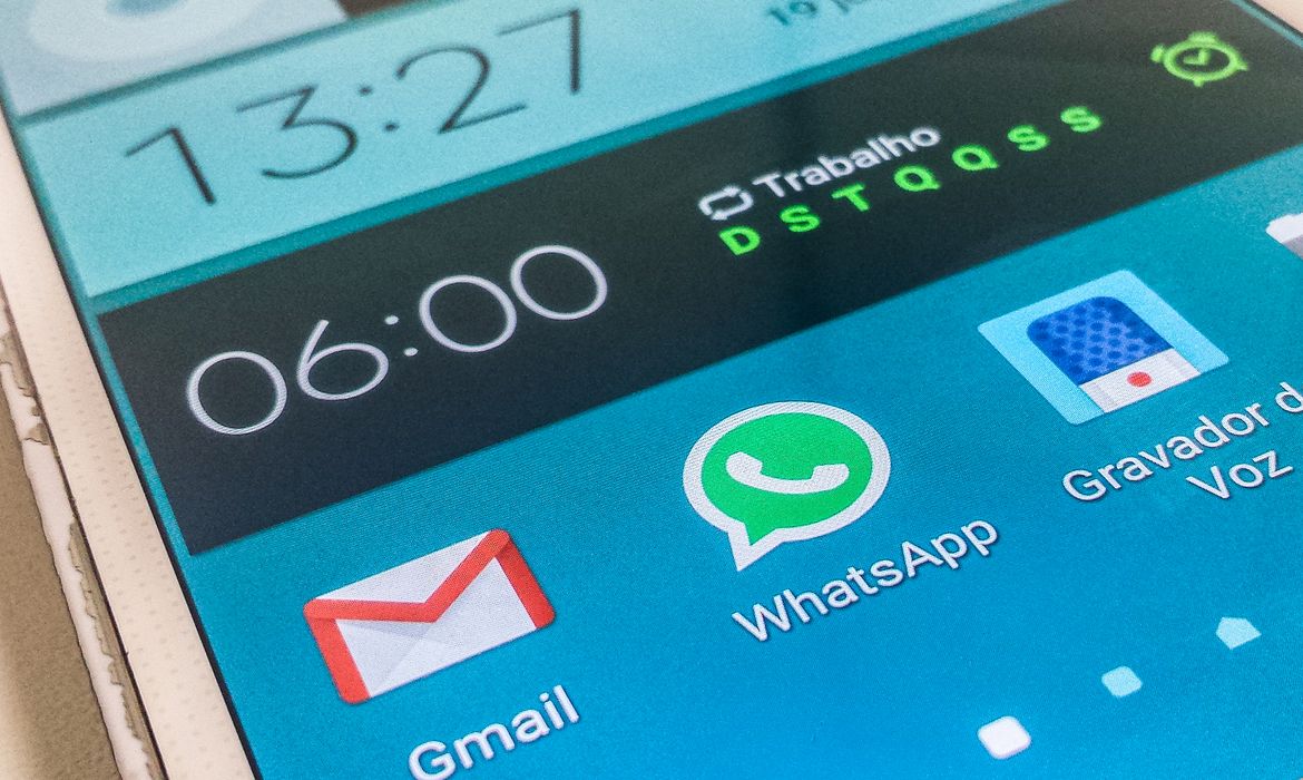 O código "invisível" do WhatsApp que permite ler mensagens sem que o remetente saiba (não é o visto por último) 2 Ícone circular verde do WhatsApp em relevo sobreposto a uma placa de circuito eletrônico vermelha com componentes e luzes de LED brilhantes.