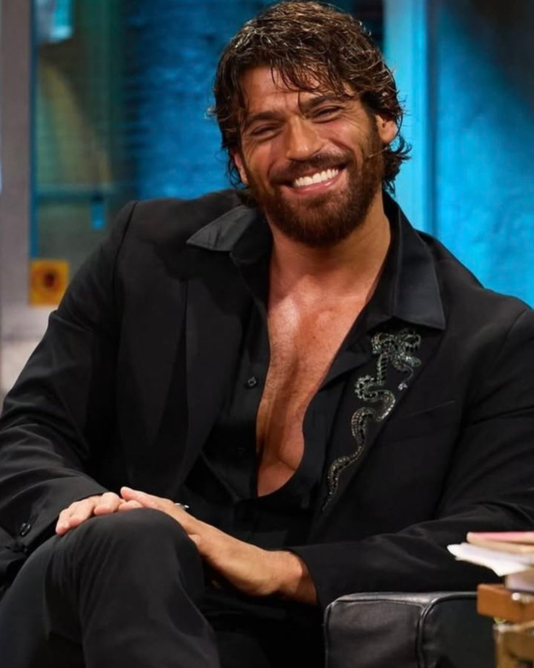 Galã de novelas turcas foi preso em operação e desabafa 3 Homem de barba sorrindo usando terno preto enquanto senta em poltrona durante entrevista