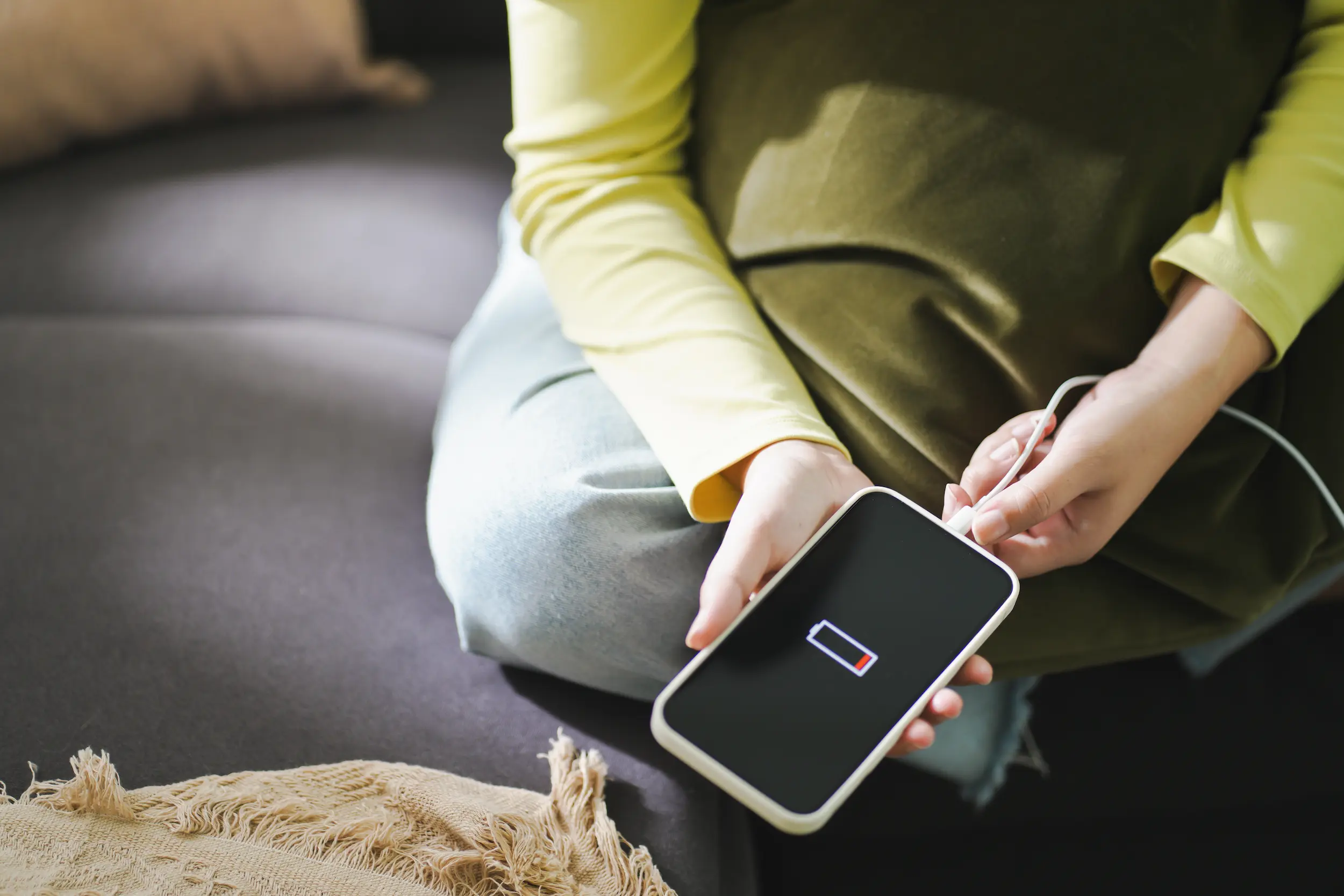 Erro fatal: Por que você nunca deve carregar o celular com a capinha (o motivo vai te surpreender) 2 Pessoa conectando o celular ao carregador enquanto o aparelho permanece com capinha.