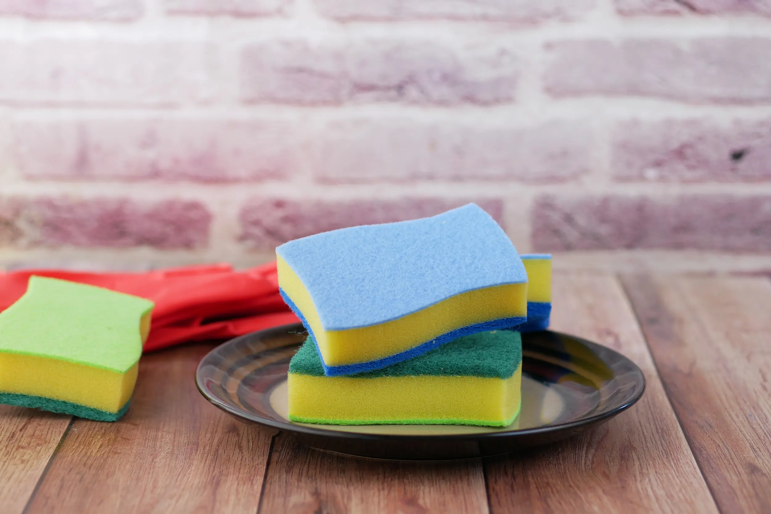 O que acontece se você colocar uma esponja dentro da máquina de lavar? O truque que as lavanderias não contam 2 Esponjas coloridas em um prato, usadas para capturar fiapos e pelos durante a lavagem das roupas.