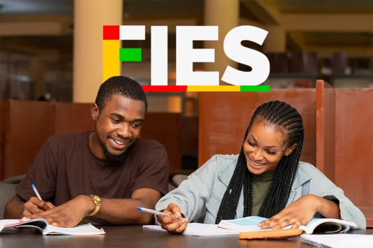 Dois jovens sorrindo estudam lado a lado em uma mesa de biblioteca com livros abertos e logo do FIES ao fundo