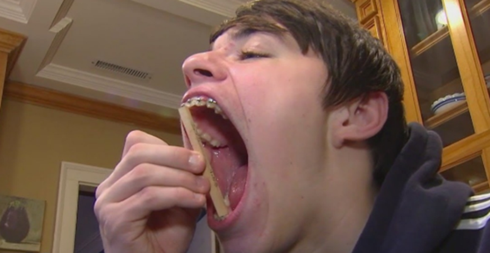 Inacreditável: Conheça o homem que detém o recorde de 'maior boca do mundo'; ele consegue colocar uma lata de refrigerante inteira! 2 Isaac Johnson abrindo a boca ao máximo enquanto segura objeto para demonstrar a medição do recorde