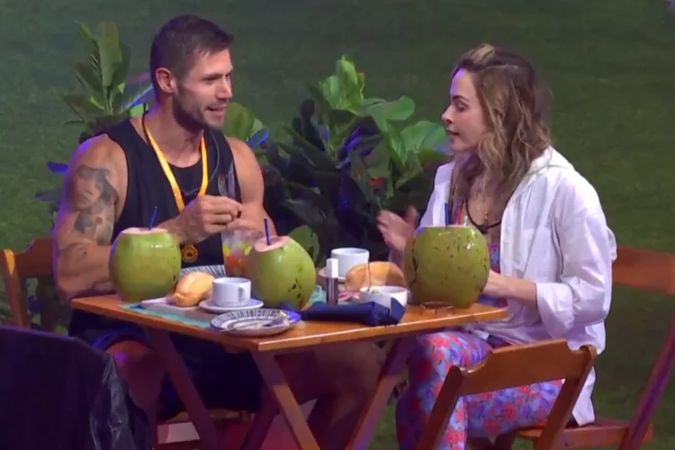 Tensão e flerte na festa de Jonas no BBB 26; veja detalhes 1 Participantes Jonas e Ana Paula sentados à mesa com drinks de coco durante conversa em clima de tensão e flerte durante festa no BBB 26