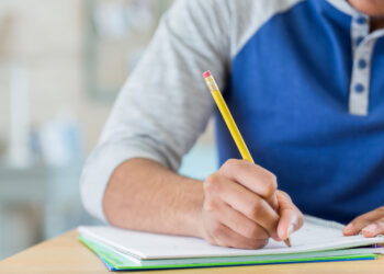 Unrecognizable student works on homework assignment