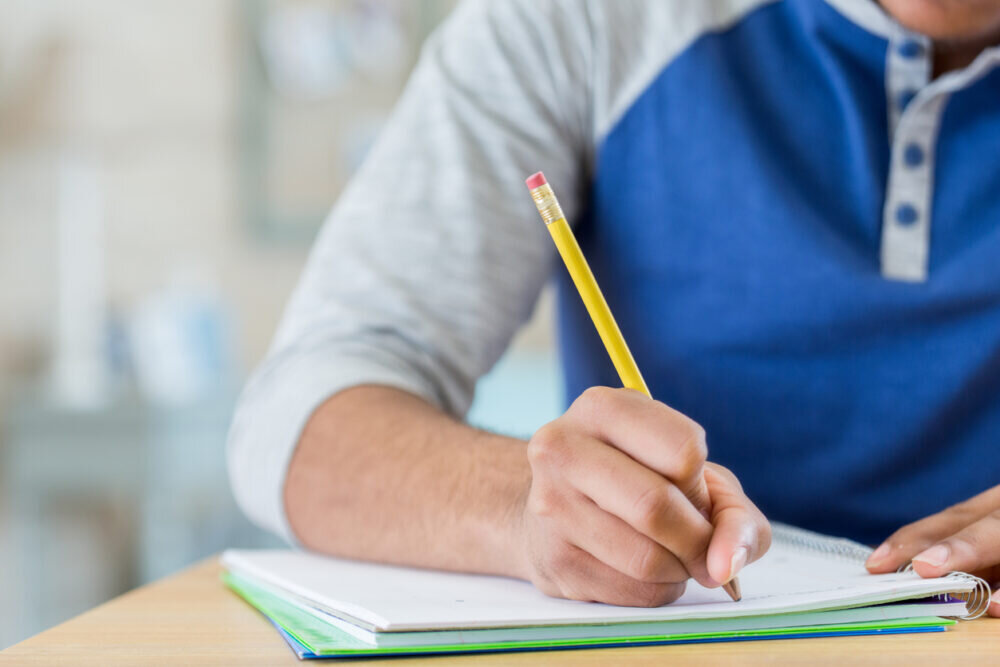 Unrecognizable student works on homework assignment