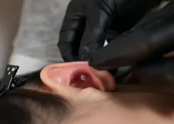 Imagem detalhada de um piercing recém-feito, com foco na área do furo e cuidados de cicatrização.