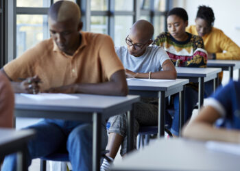 Young university students writing on exam papers