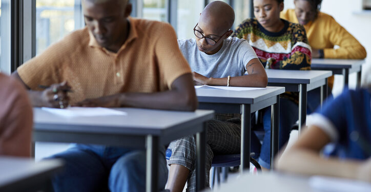 Young university students writing on exam papers