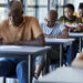 Young university students writing on exam papers