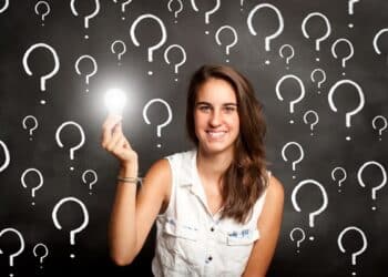 young woman holding a lightbulb with interrogation symbols