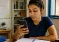 Jovem estudante consulta o celular para verificar informações sobre o cartão de confirmação do Encceja 2026