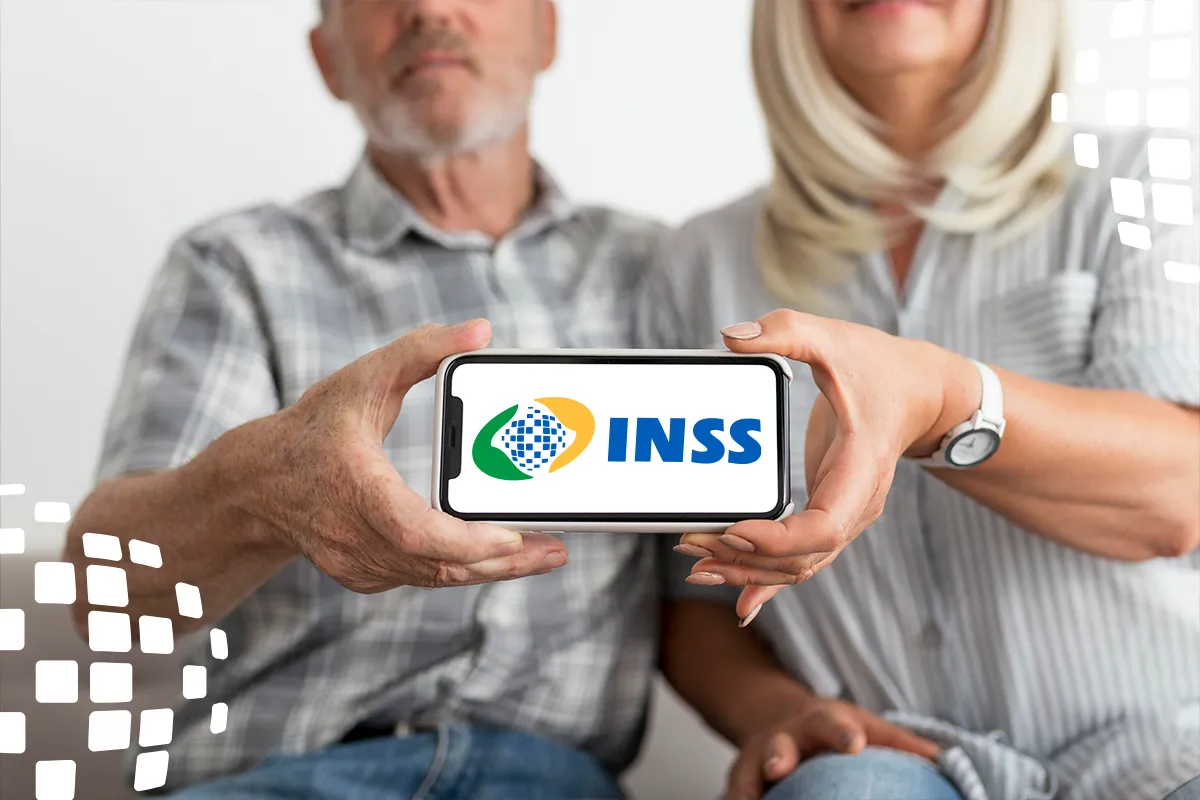 Pagamento do benefício do INSS - Consulta Casal de aposentados segurando um celular com o logotipo do INSS, representando a consulta à data de pagamento do benefício.
