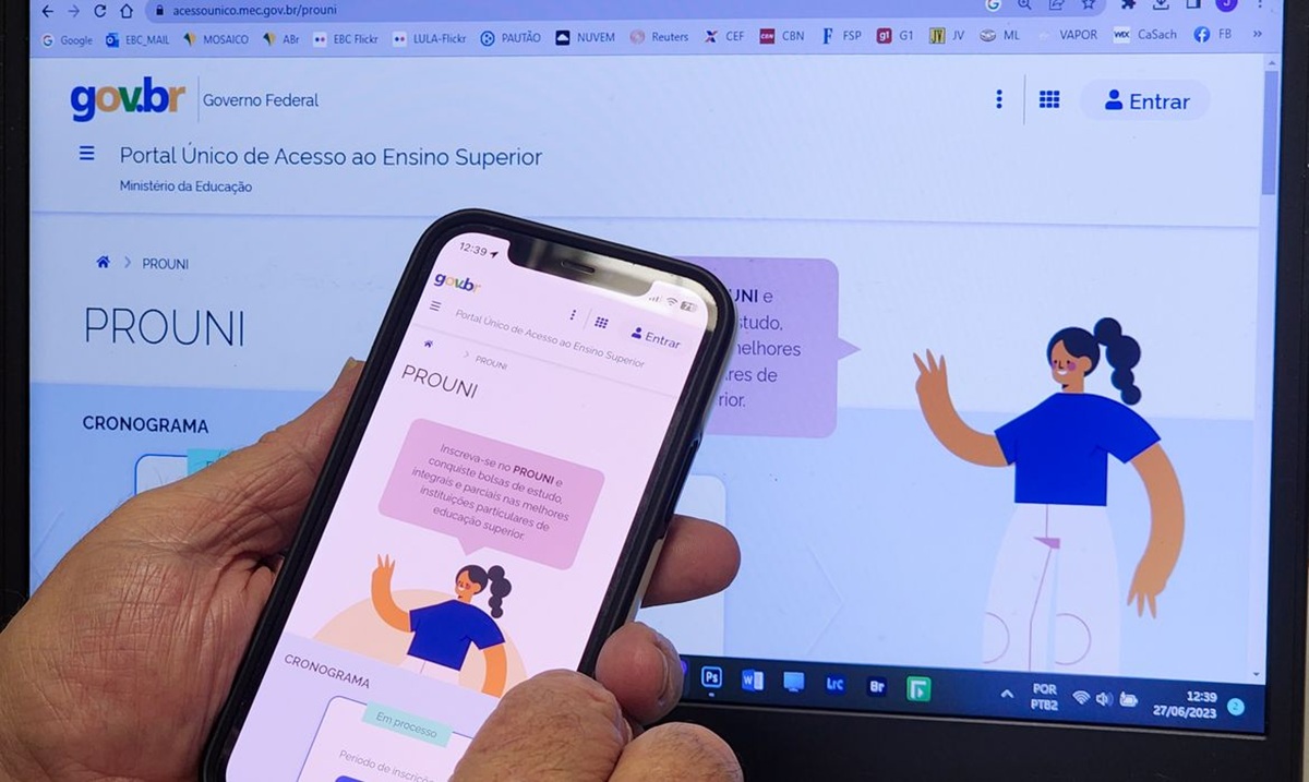 Imagem ilustrativa de mão segurando celular com a página do Prouni aberta no Portal Único de Acesso ao Ensino Superior, diante da mesma página exibida na tela do computador, em referência à comprovação das informações declaradas