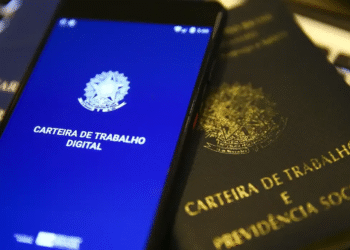 Carteira de Trabalho Digital em um celular, com a versão física ao lado, representando o acesso ao seguro-desemprego.