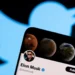 Perfil de Elon Musk aberto no Twitter em um smartphone, com o logotipo da plataforma ao fundo