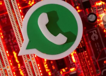 Ícone do WhatsApp sobre fundo tecnológico com luzes vermelhas.