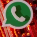 Ícone do WhatsApp sobre fundo tecnológico com luzes vermelhas.