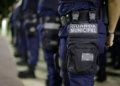 Imagem ilustrativa de agentes da Guarda Municipal perfilados em formação, com destaque para o brasão no equipamento tático, em referência ao concurso da Guarda de Goiânia