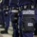 Imagem ilustrativa de agentes da Guarda Municipal perfilados em formação, com destaque para o brasão no equipamento tático, em referência ao concurso da Guarda de Goiânia