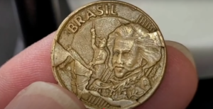 Moeda de 10 centavos de 2002 com erro de cunhagem, mostrando o detalhe de D. Pedro I e o erro de cunho quebrado.