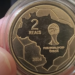 Reverso da moeda de 2 reais comemorativa da Copa do Mundo de 2014, com mapa do Brasil e taça da FIFA.