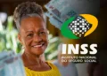 Mulher sorrindo segurando dinheiro com o logo do INSS ao fundo, ilustrando os pagamentos do INSS durante o Carnaval