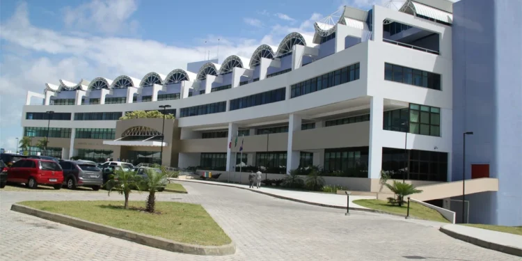 Imagem do prédio do Ministério Público da Bahia com fachada moderna e estacionamento na frente