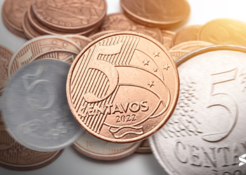 Moeda de 5 centavos de 2022 em destaque, com outras moedas ao fundo, ilustrando o valor das moedas mais recentes.