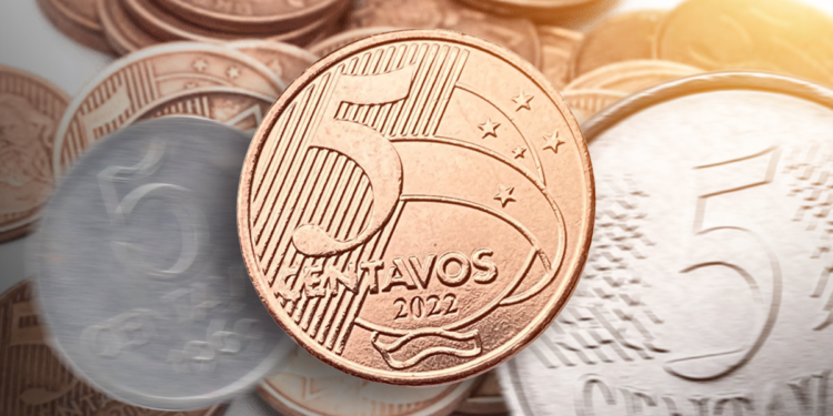 Moeda de 5 centavos de 2022 em destaque, com outras moedas ao fundo, ilustrando o valor das moedas mais recentes.