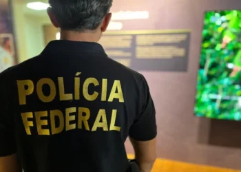 Polícia Federal: Agente da PF com camisa de identificação em ambiente institucional