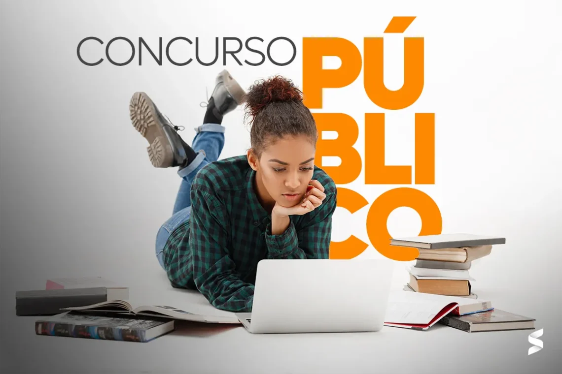 Jovem estudando para concurso público com um notebook e livros ao redor