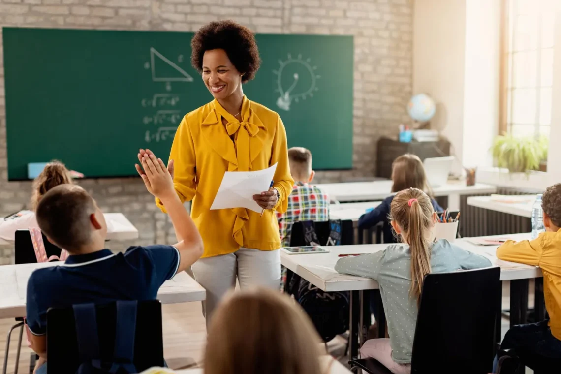 Imagem de professora interagindo com aluno em sala de aula, representando as vagas para professores no processo seletivo