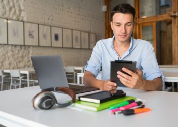 Jovem estudando em tablet, usando aplicativos para aprender matemática de forma gratuita.